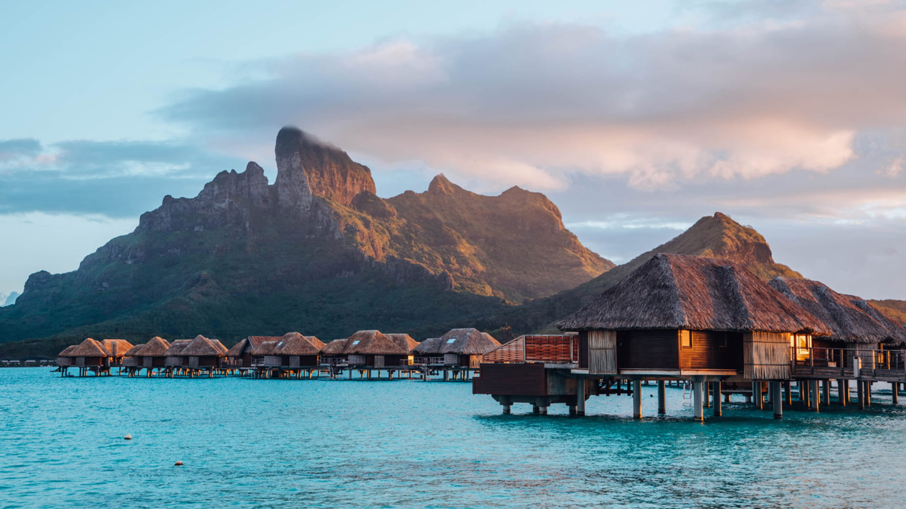 Cabins in wood design standing on the clear water in Bora Bora 