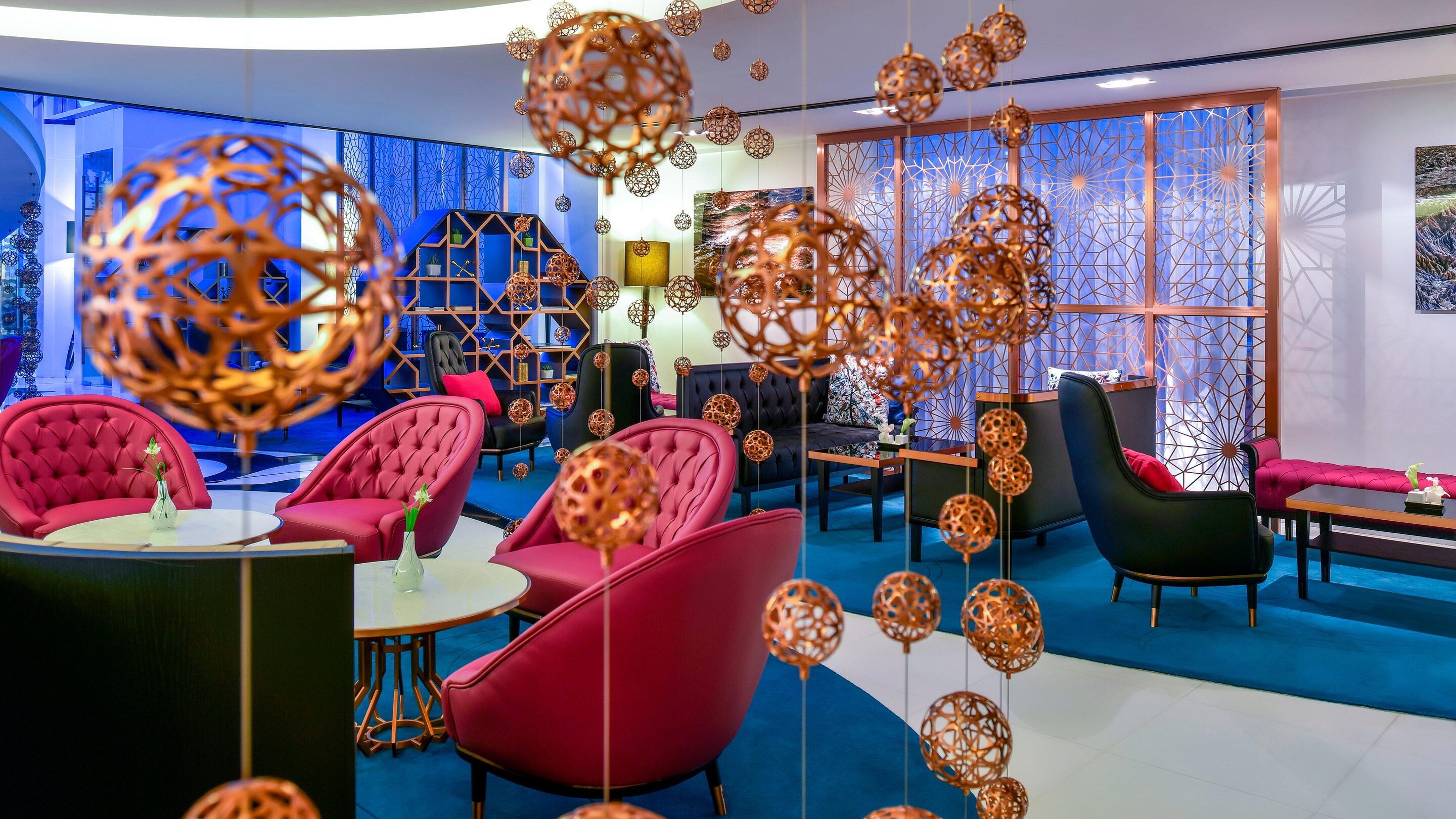 Dining area at Hotel W Doha with red seats and modern design.