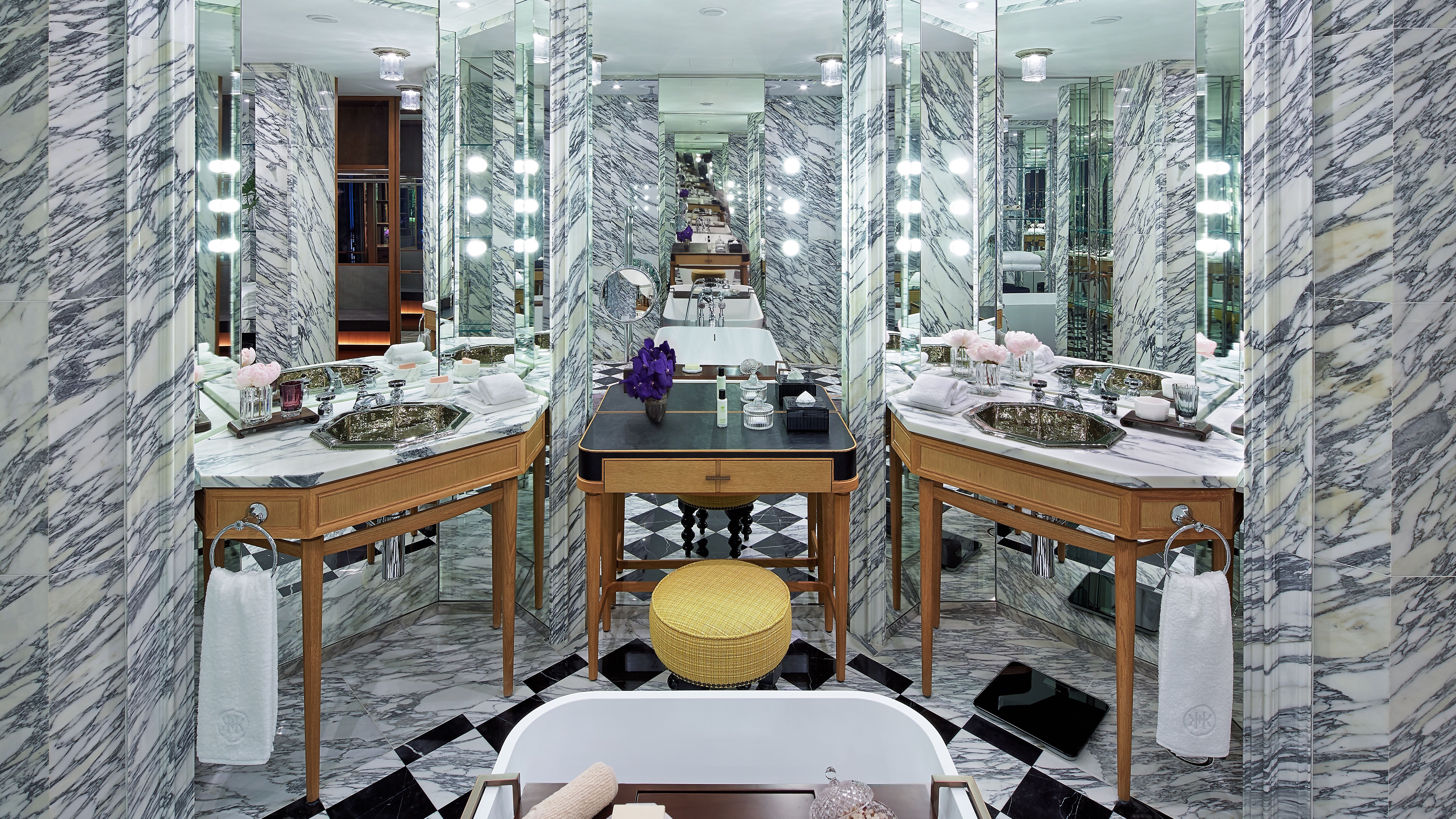 Spa room at Rosewood Hong Kong with marble design, a bath, and selfcare products.