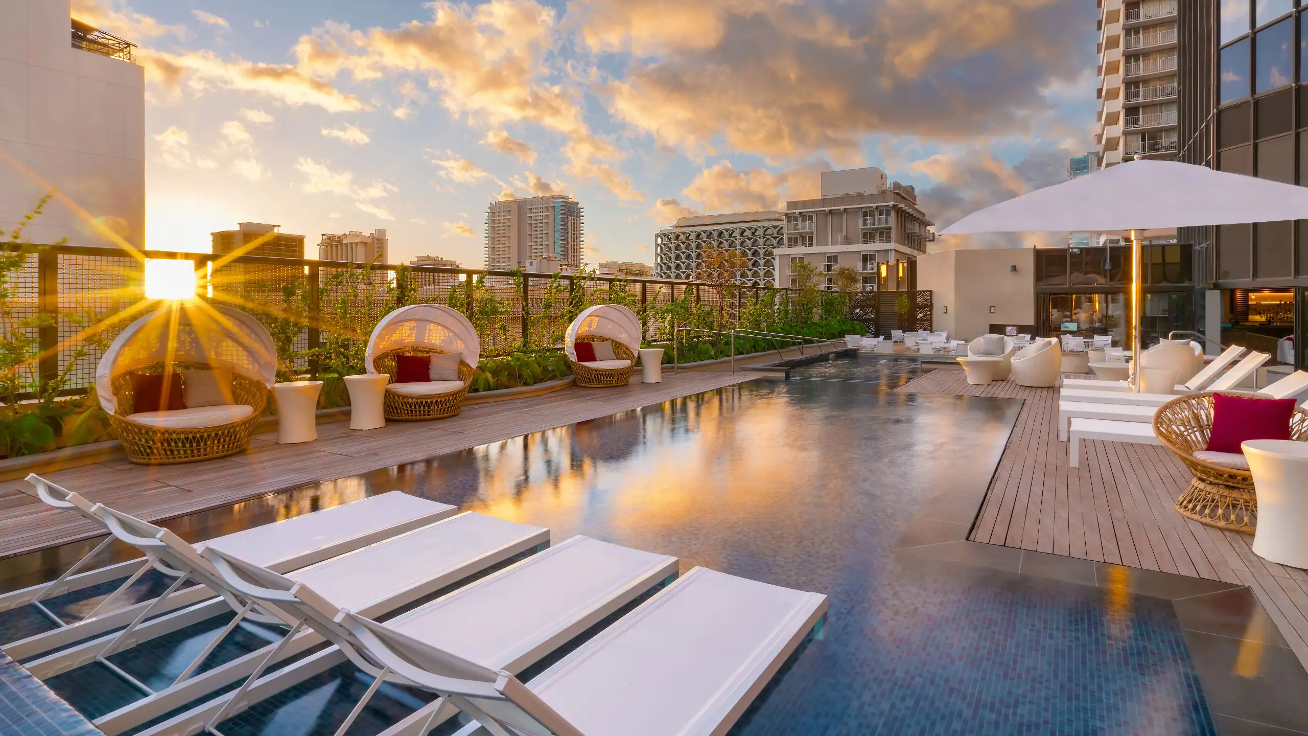 Pool area with sunbeds and chairs at Hyatt Centric Waikiki Beach.