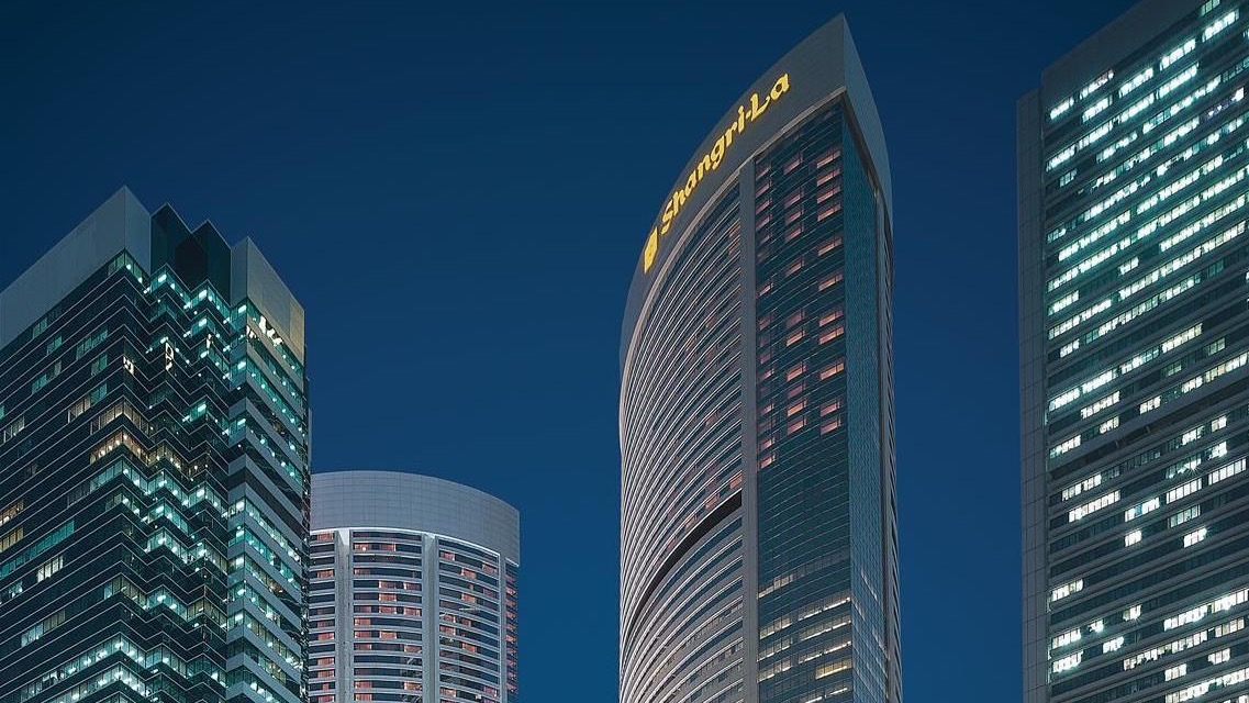 Outside view of Island Shangri-La, Hong Kong, a large building with hundreds of windows and yellow text saying: Shangri-la