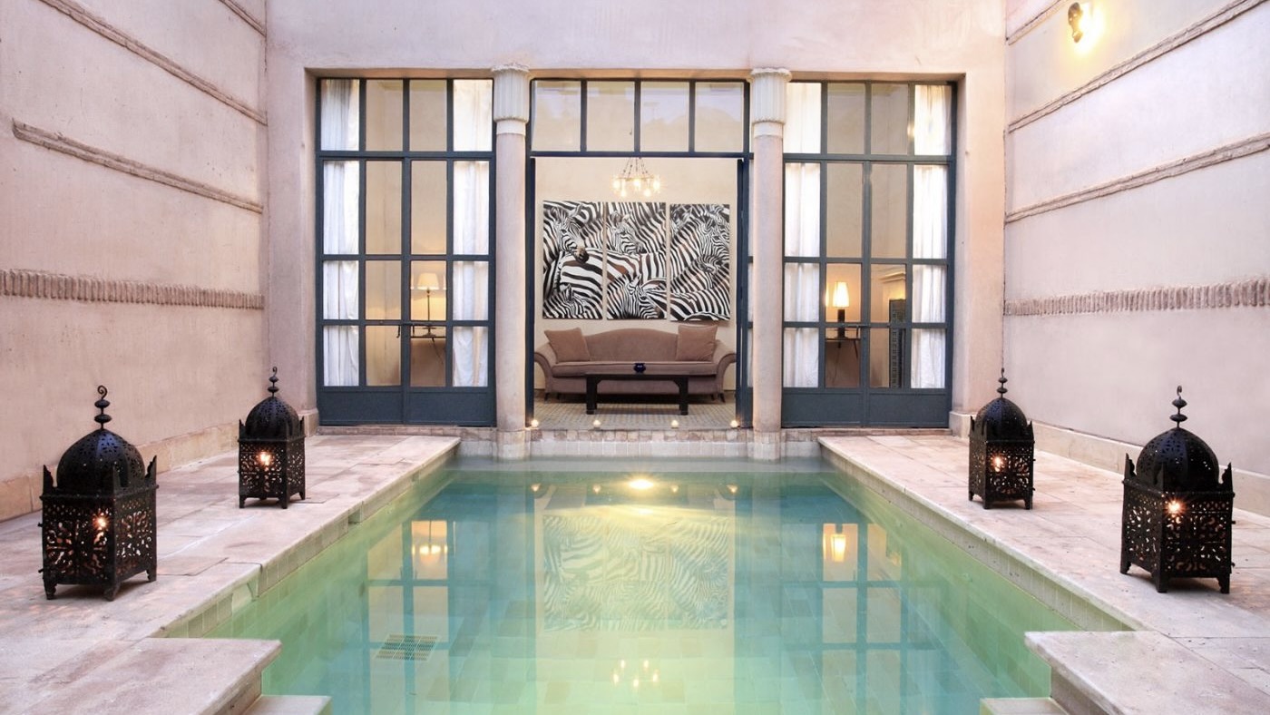 Swimming pool, white walls and open entrance to sofa area a´with zebra painting