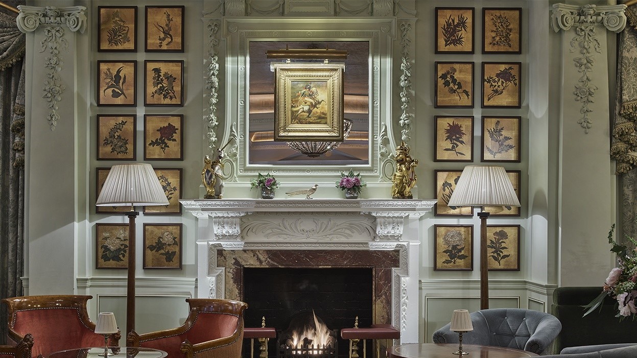 The goring bar at the goring hotel london with a fireplace and many paintings.