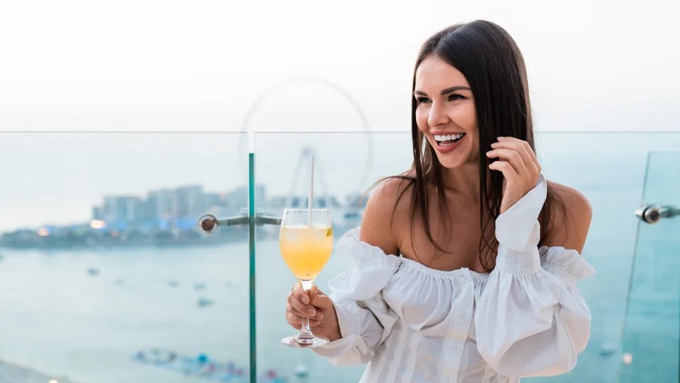 a woman laughing with a cocktail in her hand