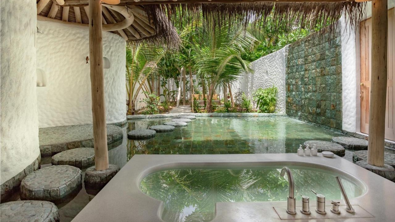 Bathtub, and palm trees in Soneva Fushi, Noonu Atoll.