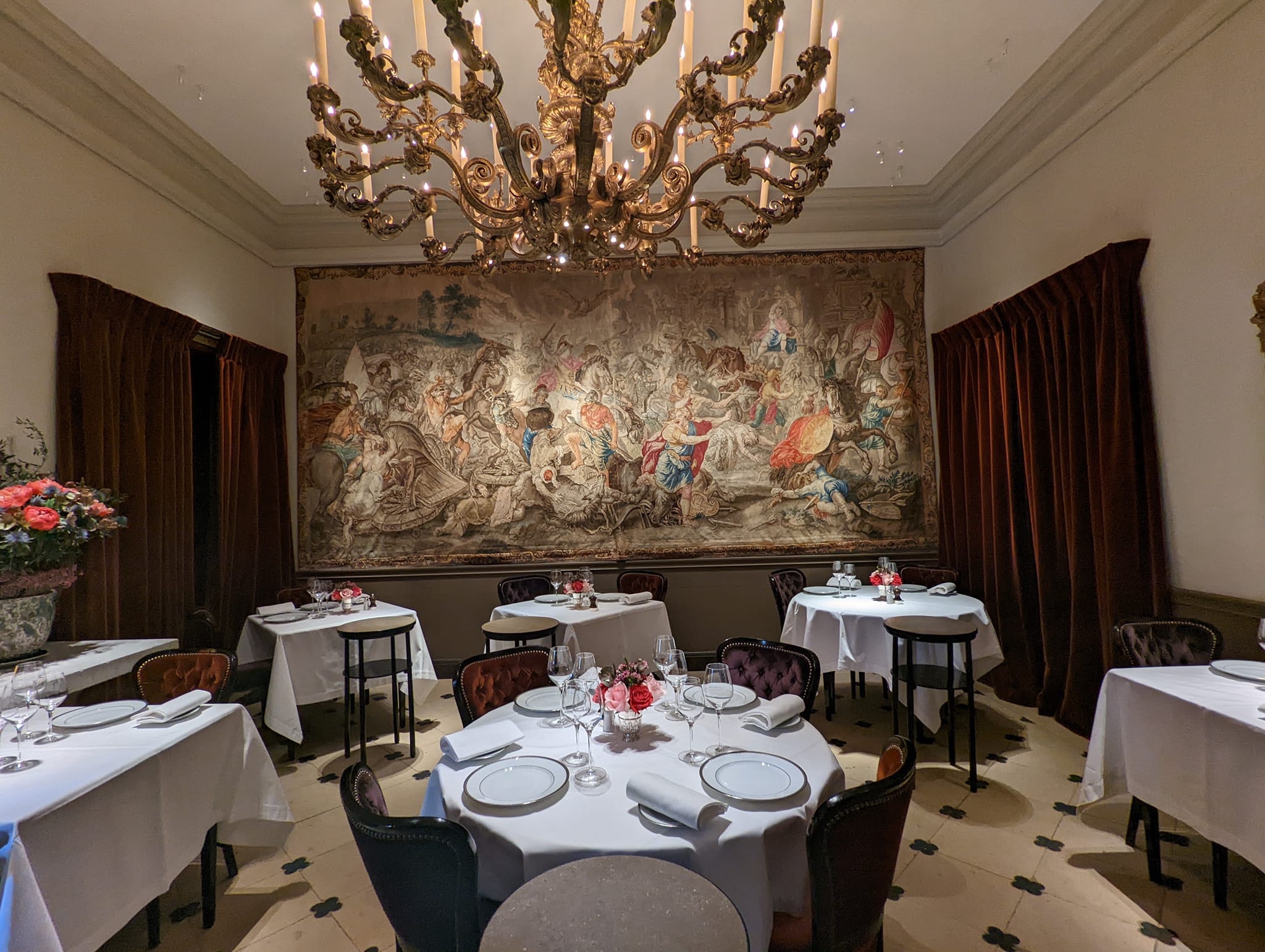 Resturant L´ambroisie with round tables and a big painting on the wall