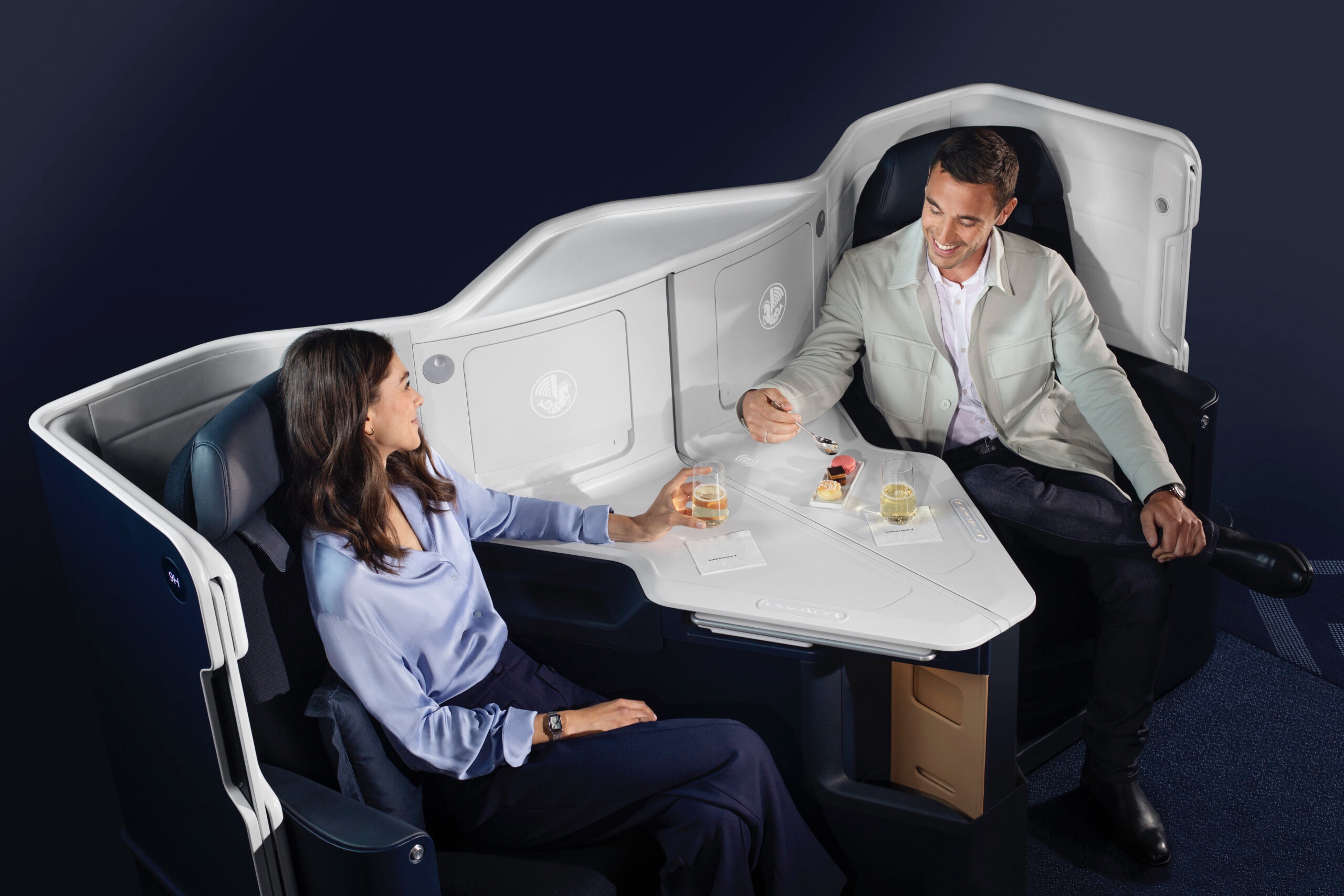Couple enjoying champagne and cookies at a businessclass flight.