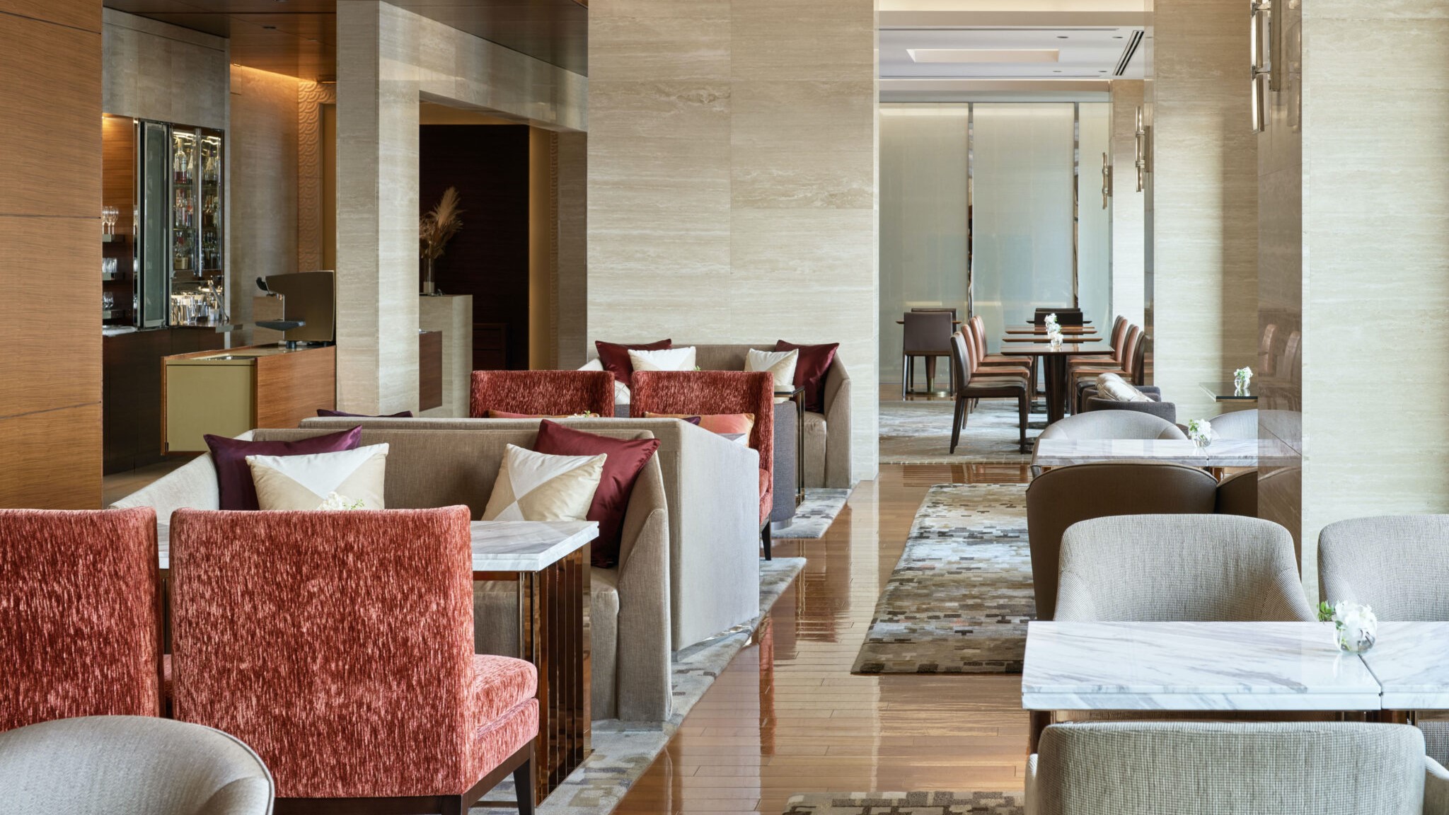 Mid-day lunch area, with marble tables, red and grey chairs,  smooth wooden floor and carpets at InterContinental Osaka.